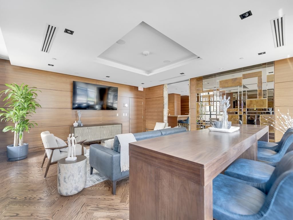 Long wood table and blue chairs beside lounge seating at 21 Clairtrell