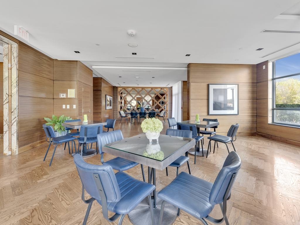 Dining tables with blue chairs and wood wall panelling at 21 Clairtrell