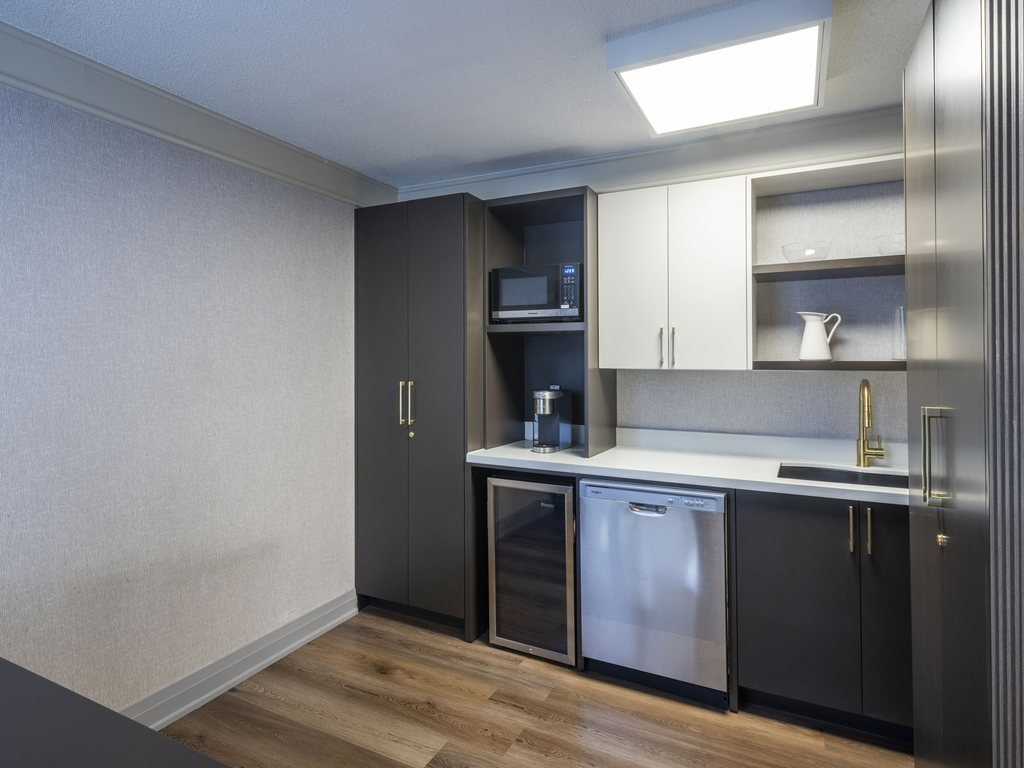 New kitchenette at 250 Queens Quay with dark cabinets, white upper cabinets and stainless steel dishwasher