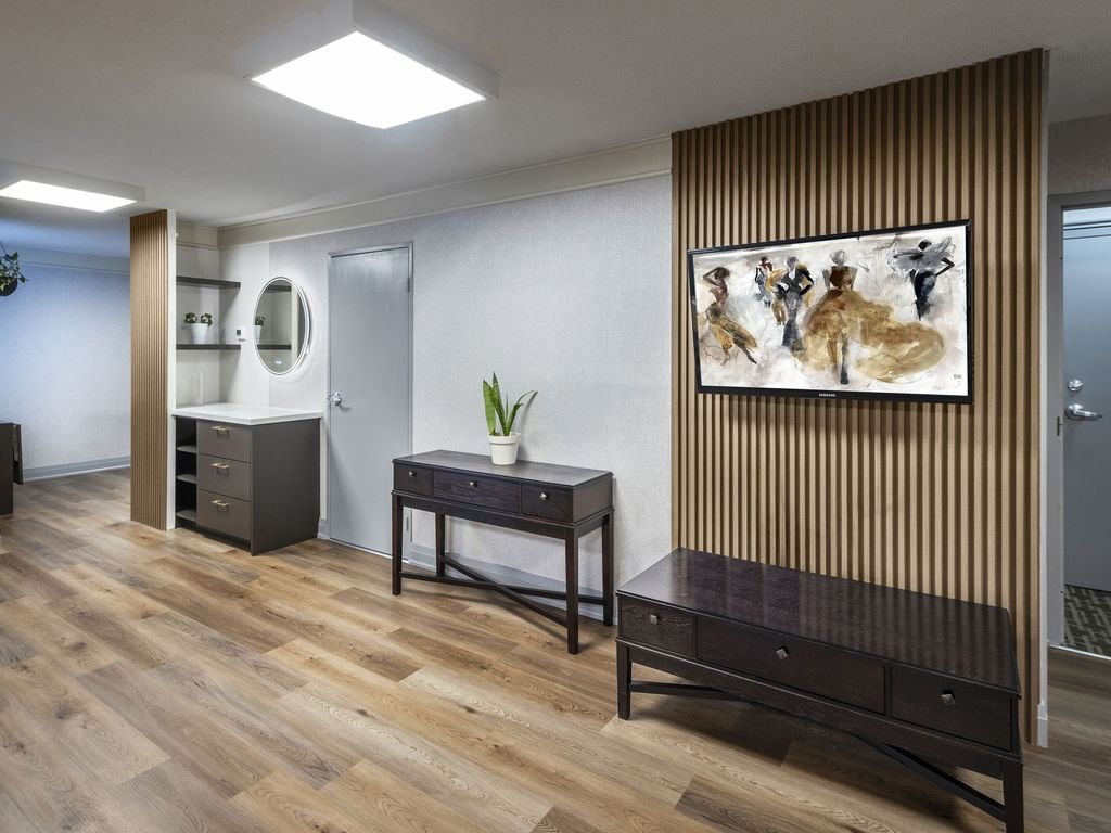 Wood-slat feature wall with framed artwork, console table and bench in the 250 Queens Quay guest suite