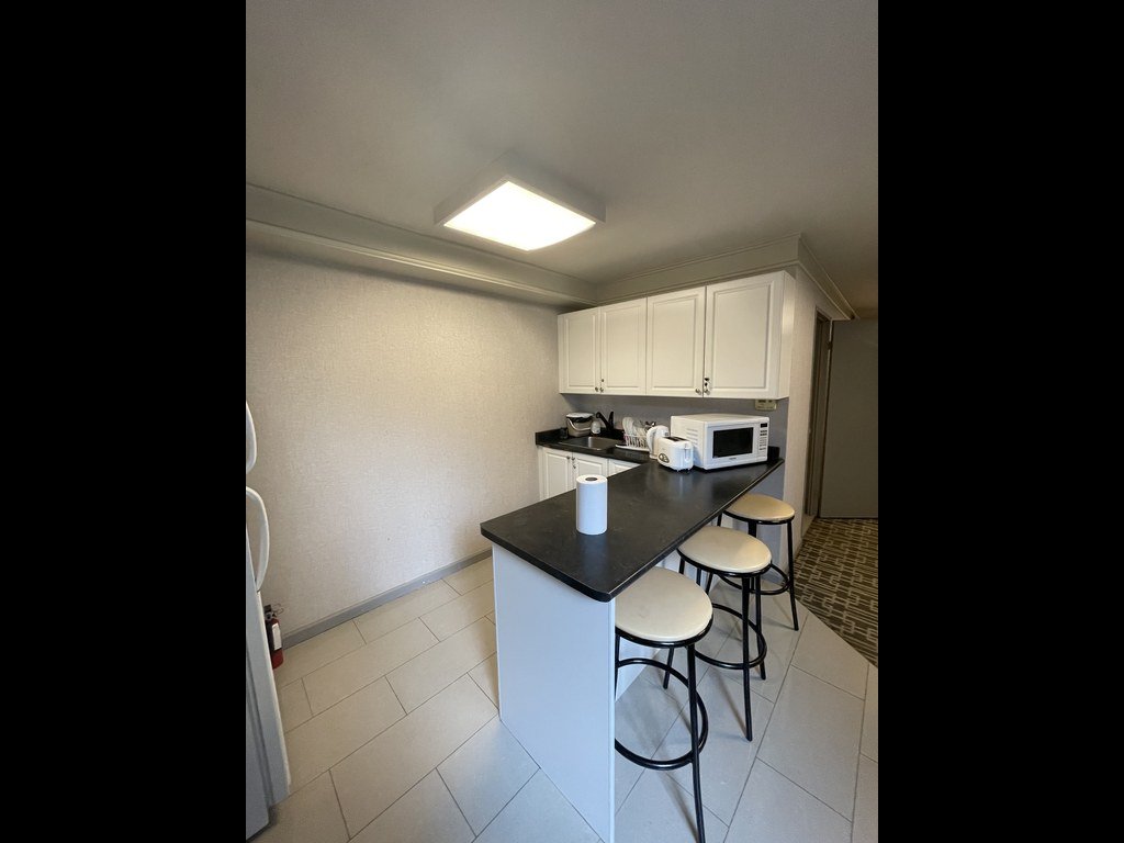 Old kitchen at 250 Queens Quay before renovation with white cabinets and a dark counter island